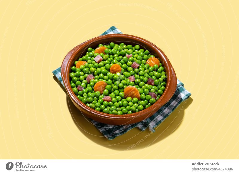 Grüne Erbsen mit Serranoschinken und Karotte auf gelbem Hintergrund grün Möhre Schinken Gemüse Gesundheit mischen Abendessen Lebensmittel Mittagessen Spanisch