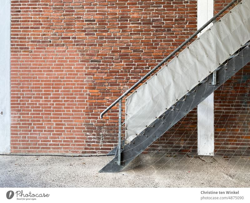 Außentreppe mit Sichtschutzplane  vor einer geflickten Klinkerwand Treppe Metalltreppe Fassade Wand Backsteinwand alt geflickte Klinkerwand Strukturen & Formen