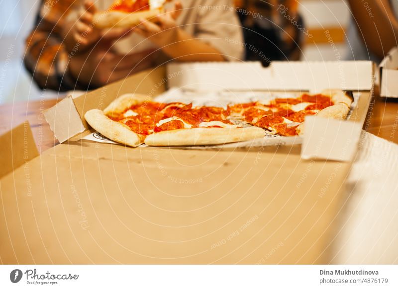 Pizza essen zu Hause. Pizza Nahaufnahme im Karton - Pizzalieferung und Essen zu Hause. Fast Food Gewohnheiten. Pizzabestellung per App und Lieferung nach Hause.