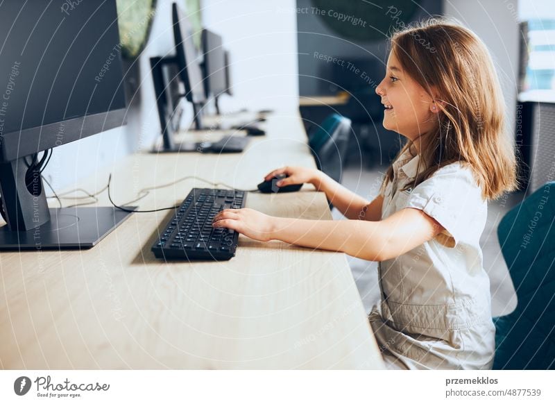 Kind lernt im Klassenzimmer in der Grundschule den Umgang mit Technologie. Schülerin benutzt Computer im Informatikunterricht der Grundschule. Zurück zur Schule