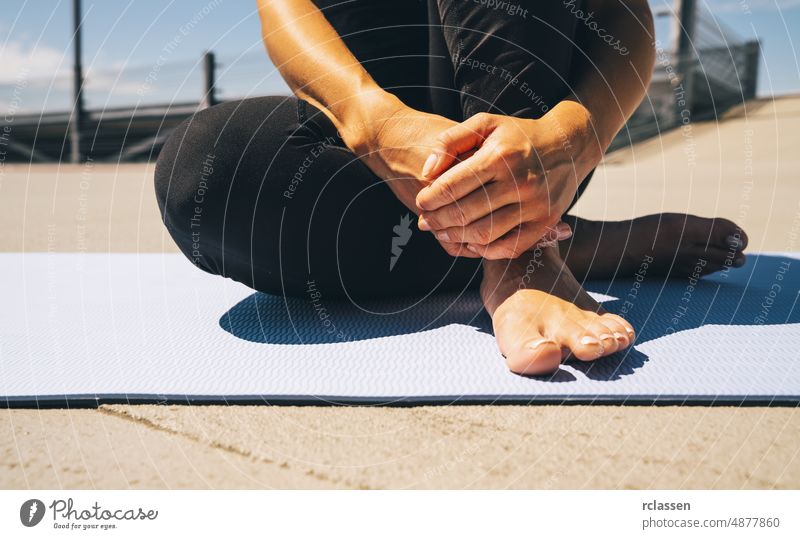 Junge Frau sitzt auf blauer Yoga- oder Fitnessmatte nach dem Training. fit halten Konzepte Bild Unterlage Pilates Kraft Sitzen Europäer Menschen beinig schön