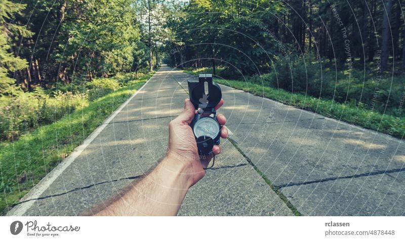 Travel Concept Mann Hand halten Kompass auf der Straße im Outback. Punkt der Ansicht Schuss Beteiligung pov Orientierung Menschen Lifestyle Orientierungslauf