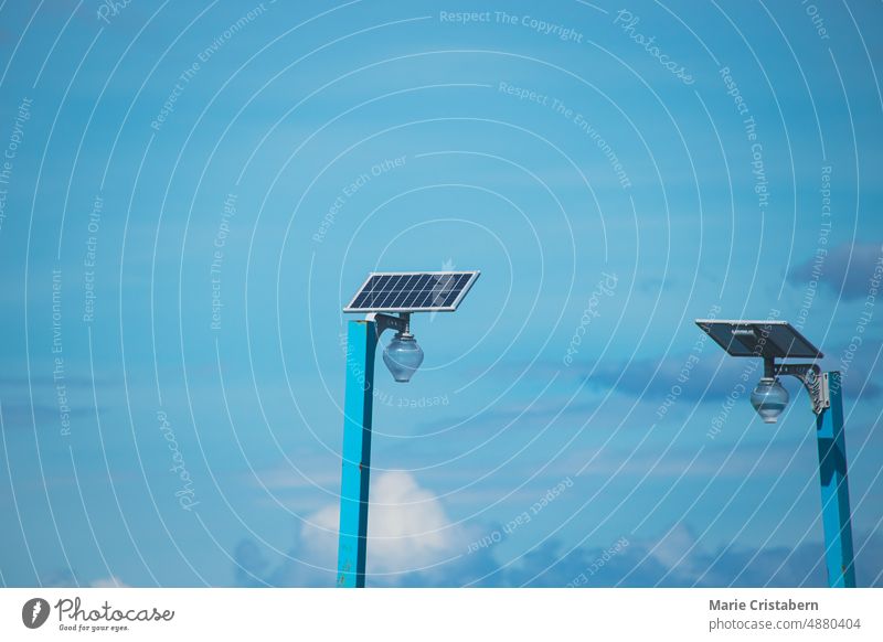 Zwei Solarmodule versorgen einen Laternenpfahl vor dem blauen Sommerhimmel Sonnenenergie saubere Energie nachhaltig ökologisch umweltfreundlich Himmel