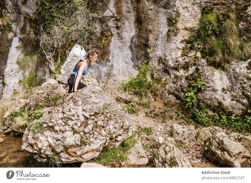 Frau mit Rucksack geht auf Felsen am Bach im Wald strömen Stehen Wanderer wandern Abenteuer Erkundung Aktivität Urlaub Backpacker Natur reisen Trekking