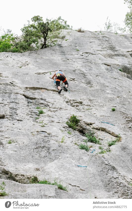 Unbekannte Bergsteigerin beim Aufstieg am Felsen im Sommer Frau Wanderer Klettern Klippe felsig Kabelbaum Abseilen Schutzhelm Abenteuer Herausforderung