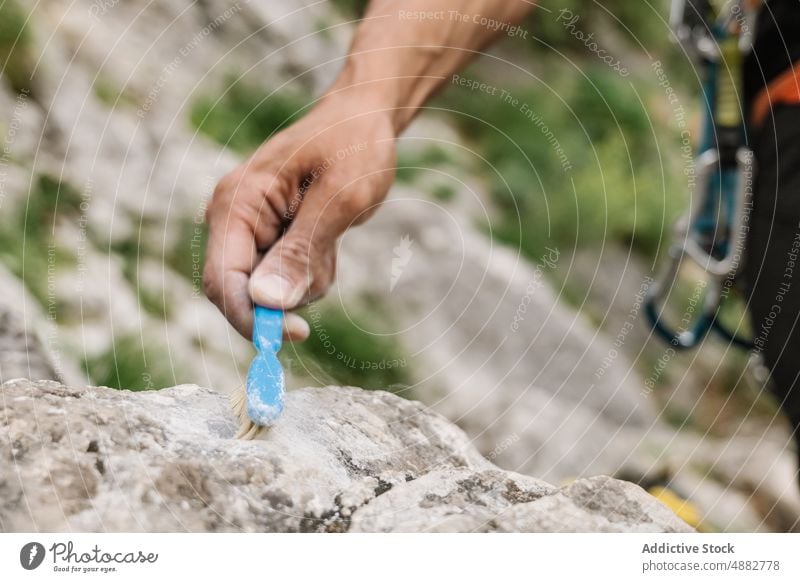Nahaufnahme von Hand Reinigung Rock mit Pinsel Wanderer Reinigen Bürste Felsen vorbereitend Klettern männlich Aufsteiger wandern Abenteuer Aktivität reisen