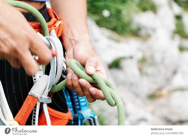 Mittelteil einer Frau, die ein Seil an einem Gurtzeug bindet Wanderer Kabelbaum Abseilen Vorderansicht vorbereiten Nahaufnahme Aufsteiger wandern Abenteuer Hand