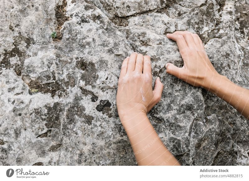 Abgeschnittene Hände, die nach einem Felsen greifen Wanderer Griff Klippe felsig Pulver Aufsteiger Hand Kreide Sport Klettern Bergsteigen wandern Abenteuer