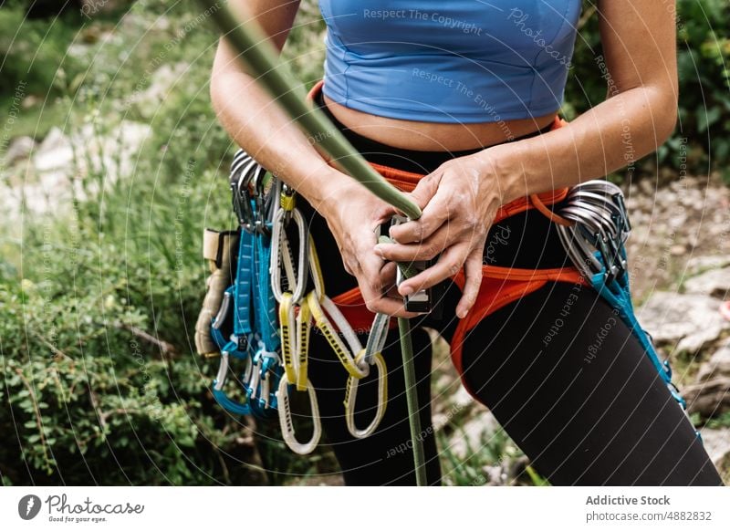 Mittelteil einer Frau, die ein Seil an einem Gurtzeug bindet Wanderer Abseilen Kabelbaum Stehen Aufsteiger vorbereiten Sport wandern Beteiligung Bergsteigen