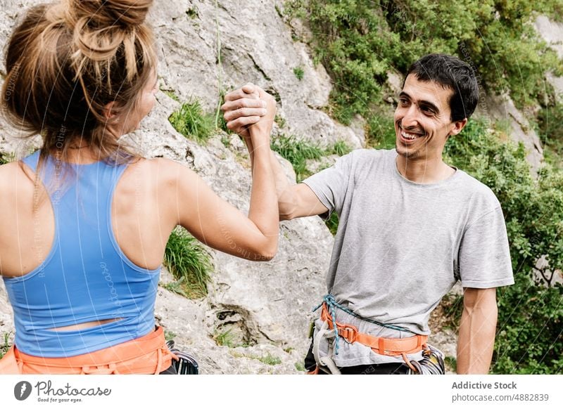 Glückliches Paar hält Hand auf Klippe Lächeln Beteiligung Wanderer Teamwork Fröhlichkeit Aufsteiger wandern heiter Abseilen vorbereiten Stehen Bergsteigen Sport