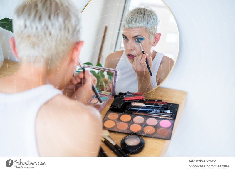 Transgender-Mann trägt Wimperntusche auf anwendend Lidschatten schwul Make-up queer Mode Individualität lgbtqi Stolz Spiegel Studioaufnahme feminin
