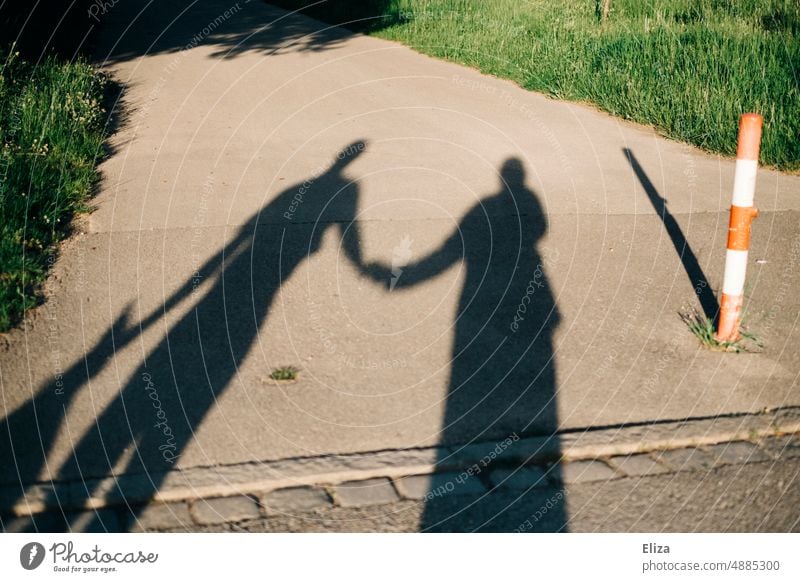 Schatten eines Paares beim Händchenhalten Beziehung zusammen Partnerschaft Zusammensein Liebespaar Verliebtheit paarweise zwei zu zweit harmonisch Zuneigung