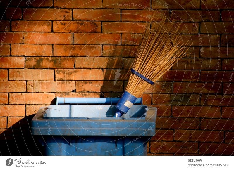 Besenstiel in Mülleimern mit Backsteinmauer als Hintergrund dreckig Sauberkeit Gerät Hygiene Werkzeug Arbeit Kehren Natur Umwelt im Freien Park kleben Symbol