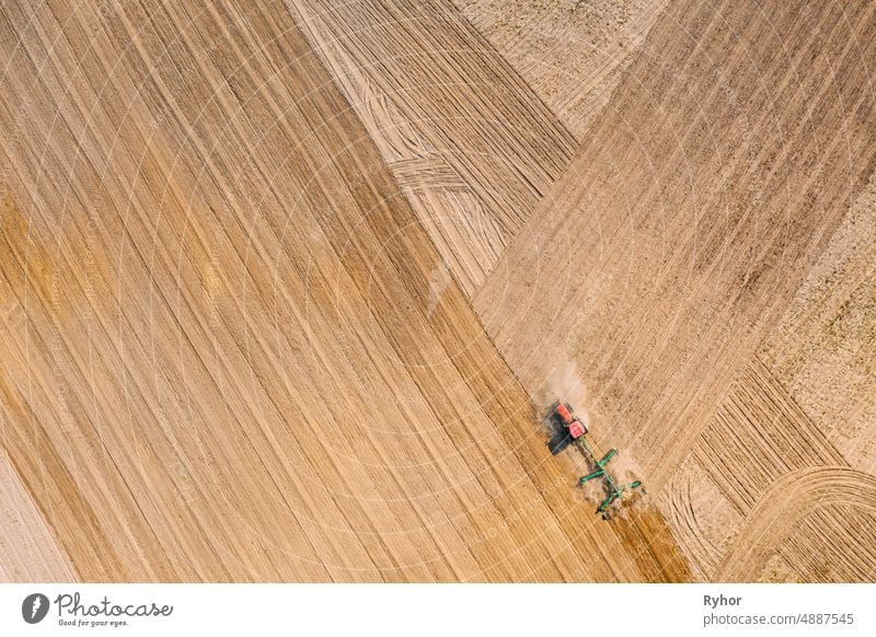 Luftaufnahme. Traktor pflügt Feld. Beginn der landwirtschaftlichen Frühjahrssaison. Cultivator Pulled By A Tractor In Countryside Rural Field Landscape Antenne