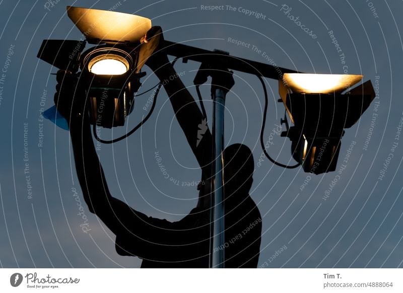 ein Mann leuchtet zwei Stufenlinsen auf Stativ ein Event beleuchter Lichttechnik Nacht stufenlinse Scheinwerfer Beleuchtung Lampe hell Außenaufnahme Abend