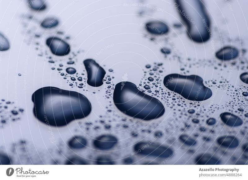 Nahaufnahme von Wassertropfen auf einer glänzenden Oberfläche in blau-violett. abstrakt aqua Kunst Hintergrund schwarz Unschärfe Schaumblase Sauberkeit