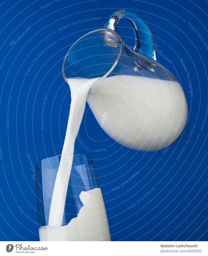 Milch einschenken mit Spritzer auf blauem Hintergrund melken Gießen platschen Kannen Glas vereinzelt Sahne weiß Gesundheit Molkerei Krug frisch fließend Tasse