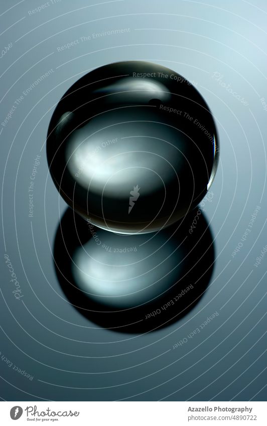Abstraktes Stillleben Bild einer Glaskugel in einem Low-Key. Geometrisches Objekt mit Reflexion, Glaskugel in einer tiefen Tonart. Kugel Minimalismus abstrakt