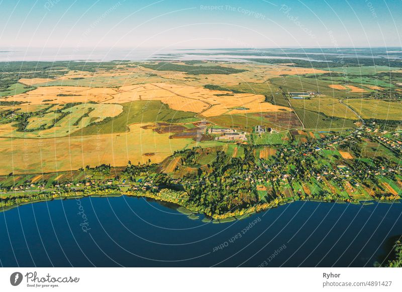 Bezirk Lyepyel, Region Witebsk, Belarus. Luftaufnahme von Wohngebiet mit Häusern auf dem Lande. Morgennebel über Lepel See und Stadt Skyline. Vogelperspektive