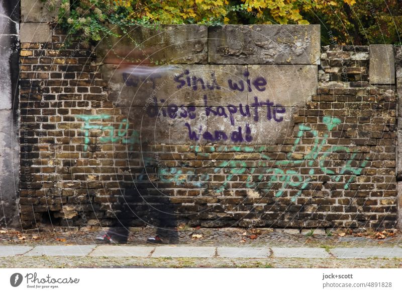 Wir sind wie diese kaputte Wand, Fußgänger geht an der alten Mauer des Friedhofs vorbei Straßenkunst Kreuzberg Berlin Philosophie Kreativität Zahn der Zeit