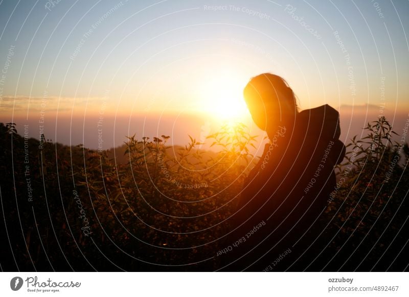 Junge Frau bewundert den Sonnenuntergang über dem Berghügel Person im Freien Sonnenaufgang Natur Rücken Sonnenlicht Lifestyle Freiheit Mädchen wandern Morgen