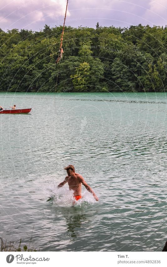 ein Mann taucht, gesprungen von einem Seil, in den See ein liepnitzsee Sommer springen Wasser Außenaufnahme Sprung Farbfoto Natur Schwimmen & Baden Freude