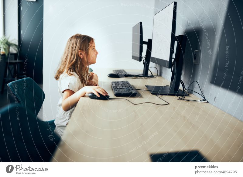 Vertiefte Schülerin, die im Klassenzimmer der Grundschule lernt, Technologie zu nutzen. Kind benutzt Computer im Informatikunterricht in der Grundschule. Zurück zur Schule