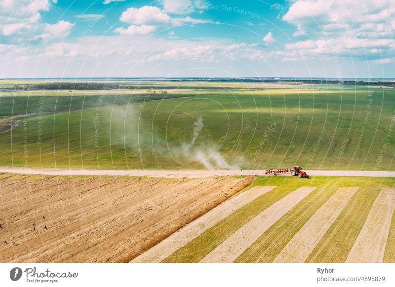 Luftaufnahme. Traktor Pflügen Feld im Frühjahr Saison. Beginn der landwirtschaftlichen Frühjahrssaison. Cultivator Pulled By A Tractor In Countryside Rural Field Landscape