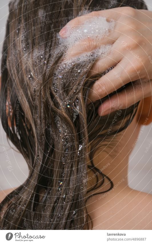 Nahaufnahme der Frau beim Waschen ihrer Haare Haarwaschmittel Mädchen Lifestyle Behaarung Pflege Behandlung nass jung Seife im Innenbereich Wasser Seifenschaum