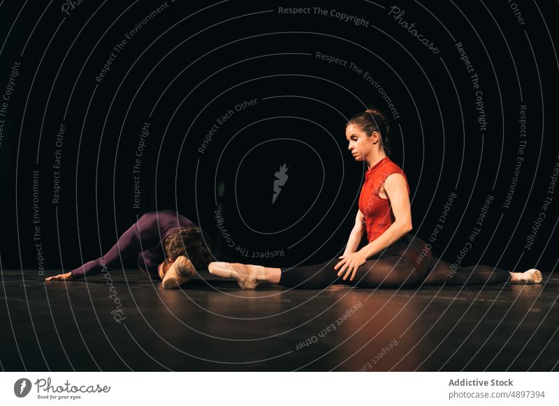 Balletttänzerinnen dehnen sich auf der Bühne Tänzer Schauplatz Probe Split Dehnung beweglich Theater Zusammensein ausführen Mann Frau Anmut Choreographie Talent