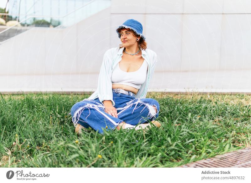 Frau auf dem Rasen sitzend Zeitvertreib Freizeit ruhen sich[Akk] entspannen Straße grasbewachsen angenehm Park feminin Hut genießen Vergnügen Gras Waldwiese