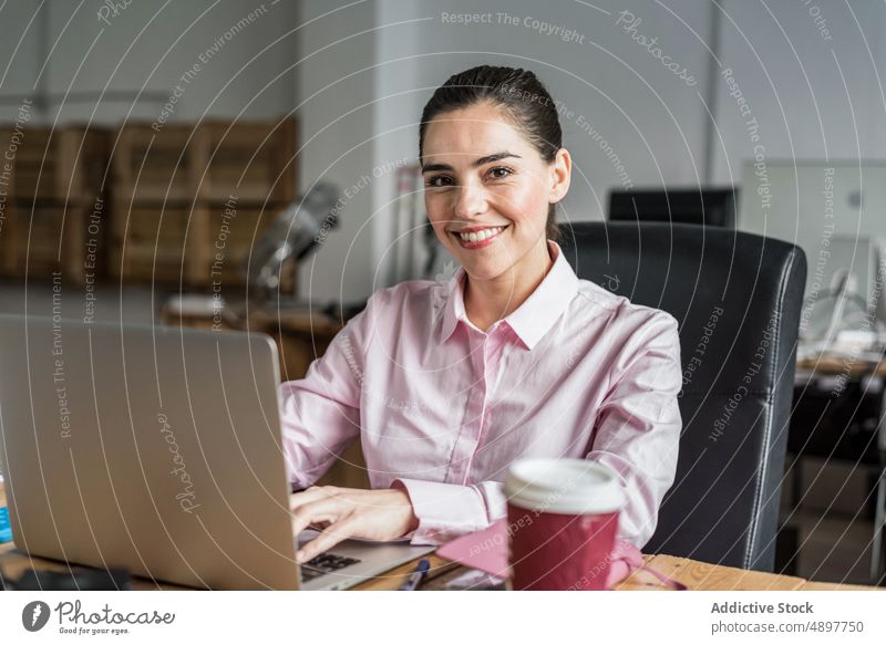 Fröhliche Frau mit Kaffee, die auf einem Laptop tippt Arbeit Tippen Browsen Büro Arbeitsplatz Projekt Business Geschäftsfrau benutzend formal Heißgetränk