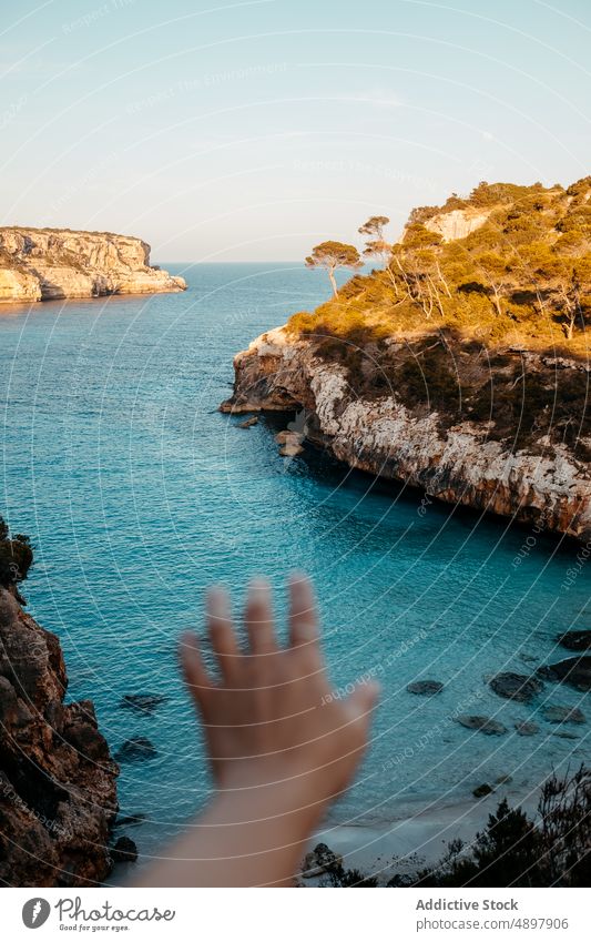 Kropfträger mit ausgestreckter Hand auf felsiger Klippe über dem Meer Person MEER Tourist Natur Meereslandschaft Landschaft malerisch sich[Akk] melden Reisender