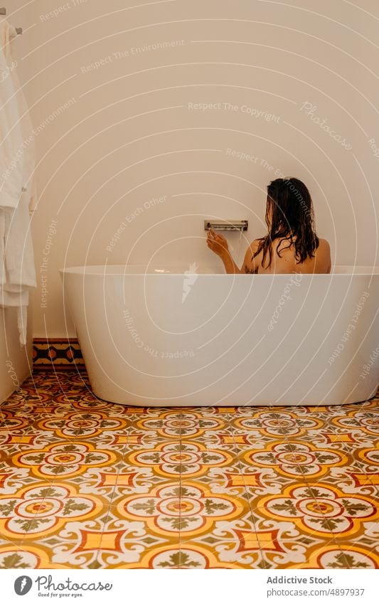 Anonyme Frau nimmt ein Bad in einem modernen Badezimmer Badewanne Hygiene Azulejo Innenbereich Waschraum Wellness Körperpflege Fliesen u. Kacheln