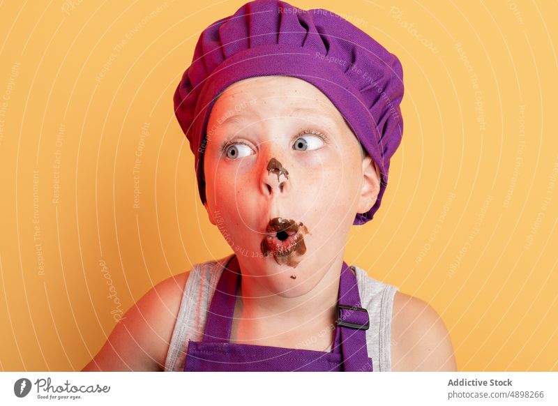Lustiger Junge mit Schokolade überzogen Kind Küchenchef unordentlich süß Koch Helfer kulinarisch schelmisch Leckerbissen Mund geöffnet Erstaunen erstaunt omg