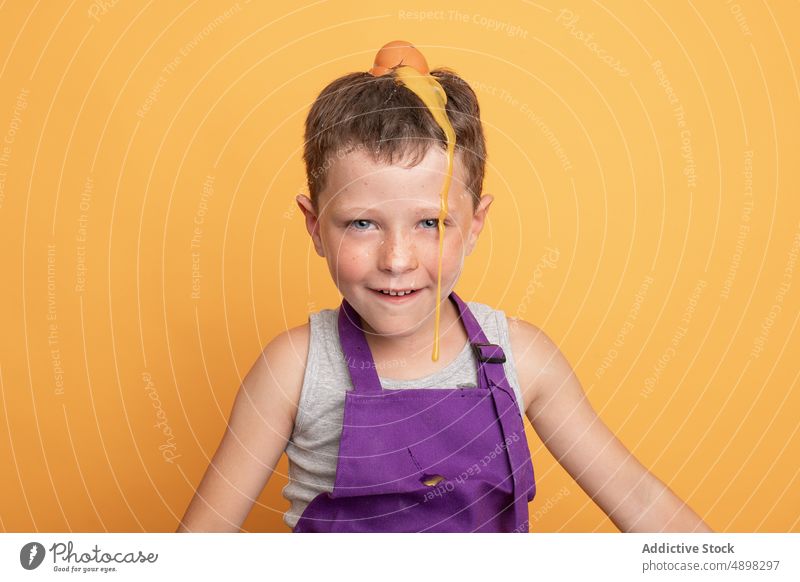 Schelmischer Junge mit Ei auf dem Kopf Kind Küchenchef Koch kulinarisch Spaß haben schelmisch roh ungehorsam natürlich widerspenstig Helfer Produkt Lächeln