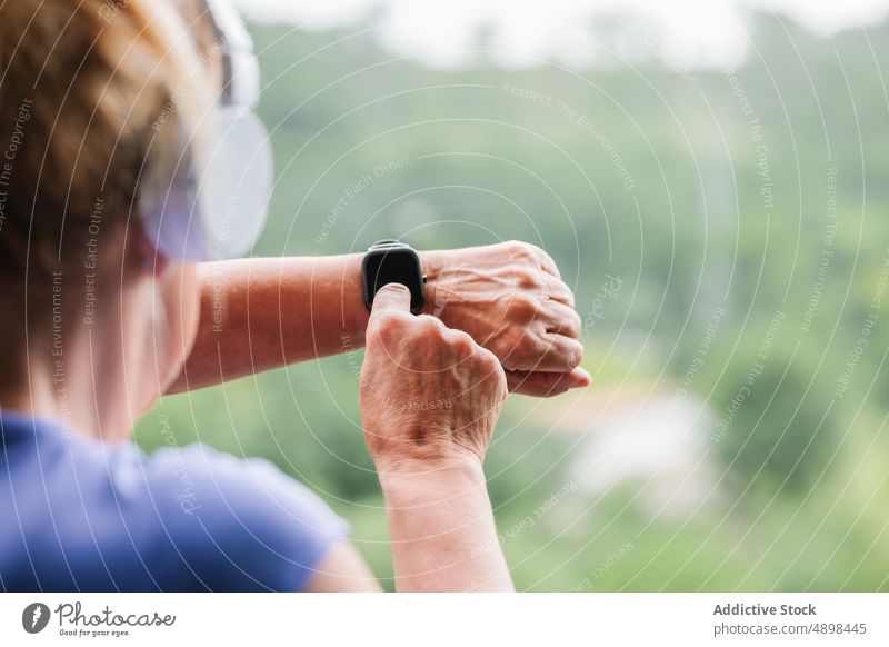 Hands Einrichten der Fitness-Smartwatch vor dem Training Hände intelligente Uhr Senior Frau Bildschirm berührend abgeschnitten Nahaufnahme passen aktiv