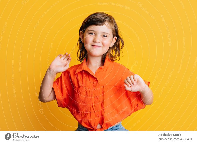 Fröhliches Mädchen lächelnd auf buntem Hintergrund Lächeln Glück Stil farbenfroh hell Kind lässig Porträt Freude gestikulieren Kindheit wenig pulsierend