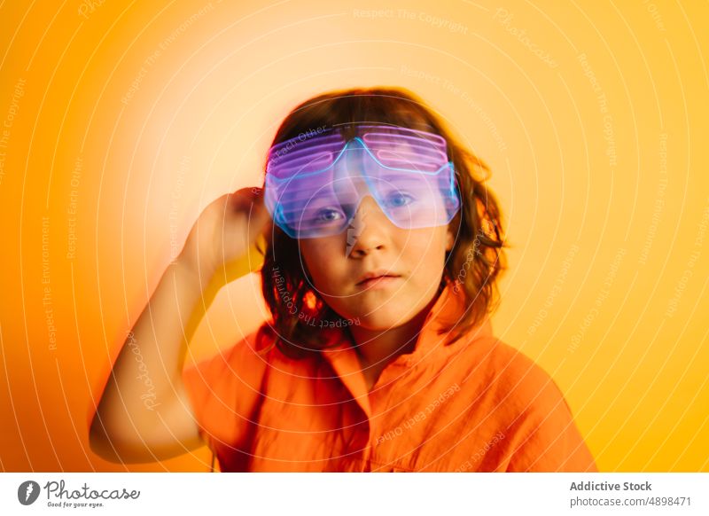 Kleines Kind mit Neonbrille neonfarbig Brille futuristisch Party Schutzbrille farbenfroh hell Kindheit glühen Tracht Farbe wenig pulsierend festlich