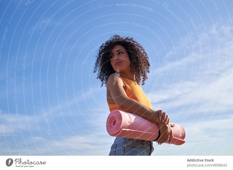 Hispanische Frau mit Yogamatte am Meeresufer Unterlage Ufer MEER Gesunder Lebensstil Training Hobby Küste Zeitvertreib Vorschein Stil Sommer feminin Aktivität