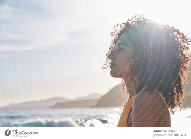 Hispanische Frau am Meer an einem sonnigen Tag Straße Vorschein Stil Sommer feminin Blauer Himmel Sonnenlicht genießen ethnisch hispanisch heiter positiv Blick