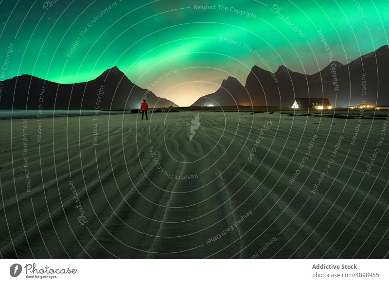 Anonymer Reisender beim Betrachten der Berge unter dem Sternenhimmel und den Nordlichtern Berge u. Gebirge Natur Hochland Landschaft Astronomie Polarlicht Mann