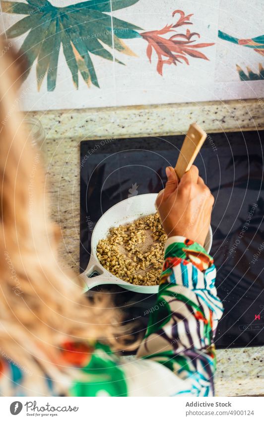 Unbekannte Frau brät Quinoa auf dem Herd braten Küche kulinarisch selbstgemacht Speise Koch Mahlzeit Spachtel rühren lecker vorbereiten heimwärts Rezept