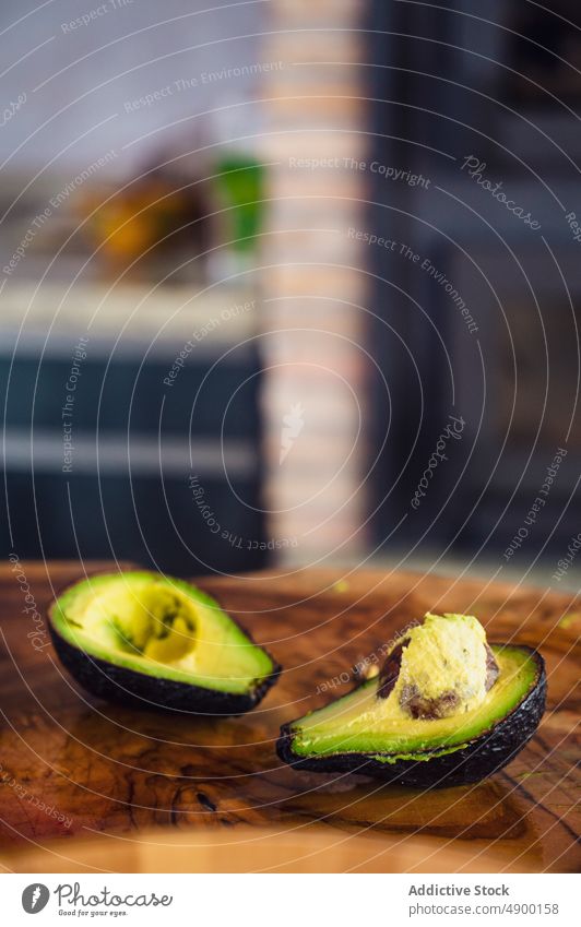 Halbierte Avocado auf Holzbrettchen Hälfte frisch Platte hölzern Küche gesunde Ernährung Diät Samen reif Bestandteil heimwärts organisch Vitamin Veganer