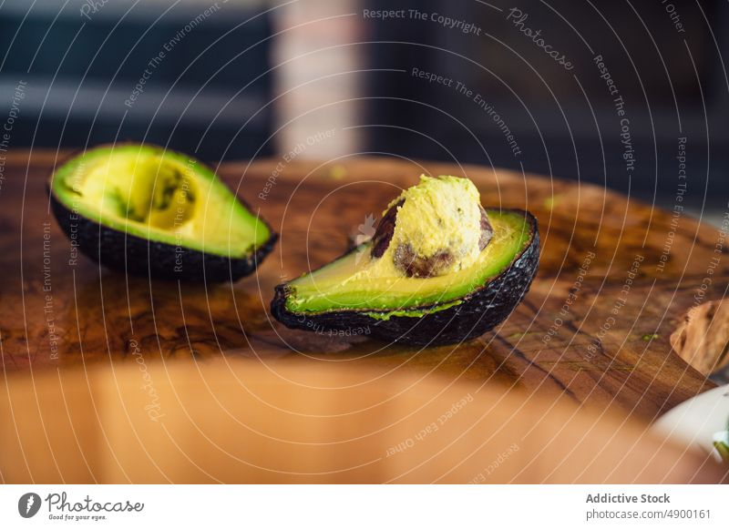 Halbierte Avocado auf Holzbrettchen Hälfte frisch Platte hölzern Küche gesunde Ernährung Diät Samen reif Bestandteil heimwärts organisch Vitamin Veganer