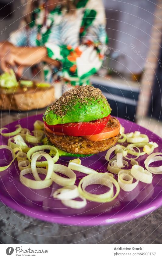 Frischer veganer Burger auf dem Teller Veganer Avocado Gemüse Pastetchen Paprika Tomate Zwiebel Mittagessen Küche Koch gesunde Ernährung Vegetarier Vitamin