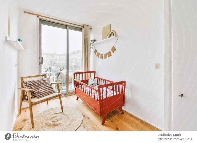 Interieur eines Zimmers mit einer Holzkrippe Babybett Raum im Innenbereich modern Design rot Wand Appartement Bär gemütlich Bett heimwärts weiß hell