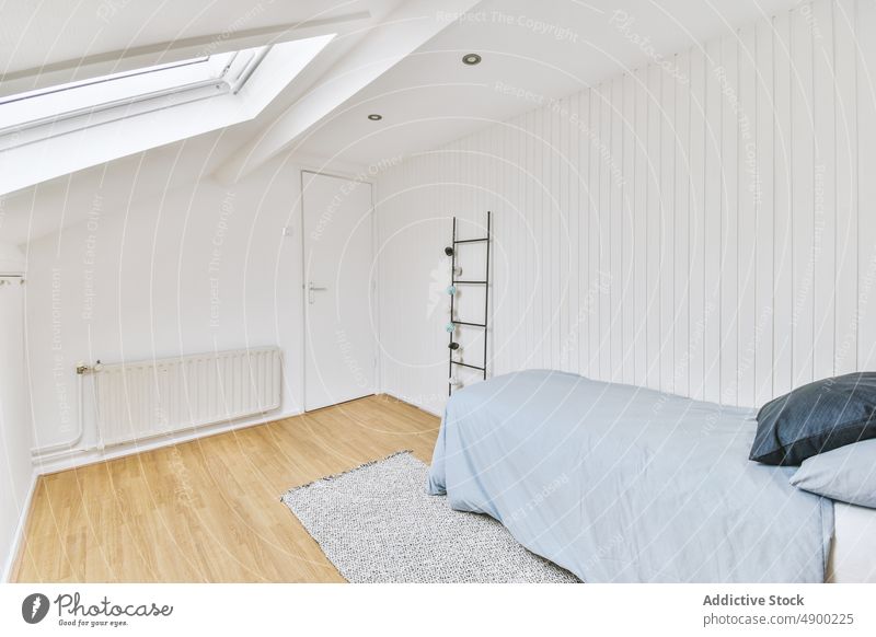 Bequemes Bett mit weißen Wänden neben einem Heizkörper Schlafzimmer Appartement gemütlich Tür Möbel Raum im Innenbereich Design Haus elegant Eingang Anwesen