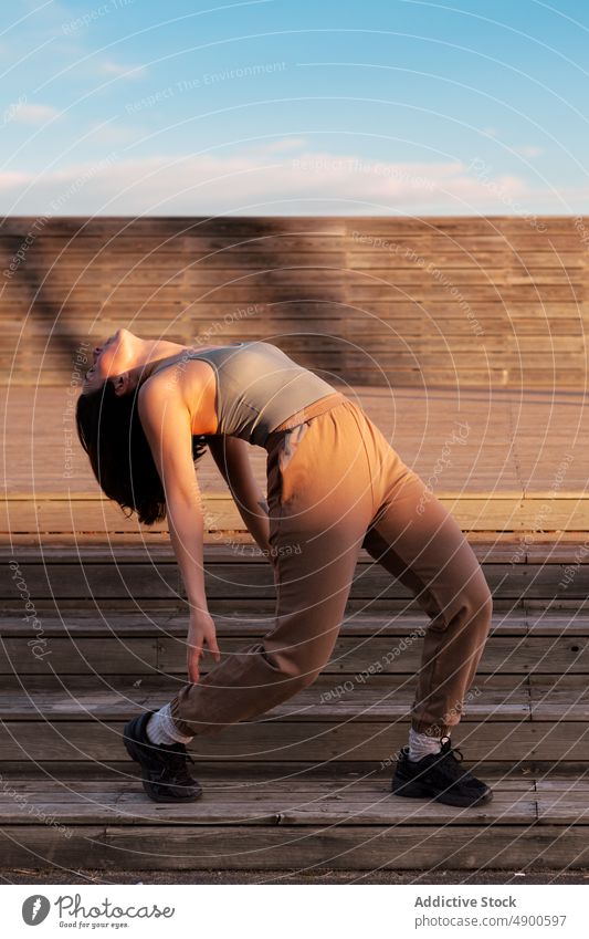 Frau streckt Rücken auf der Straße Sportlerin Übung Aufwärmen Dehnung Wegbiegung Training Gesunder Lebensstil Backend Figur beweglich Treppe Bestimmen Sie