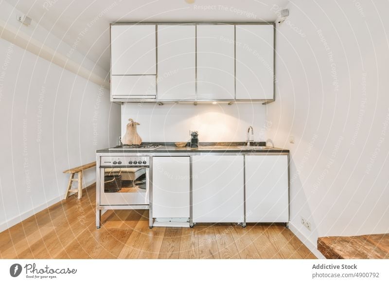 Moderne Küche mit Geräten und weißen Schränken Innenbereich Vorrichtung Möbel Appartement sehr wenige Stil Herd Unterkunft wohnbedingt Gas Kocher heimwärts